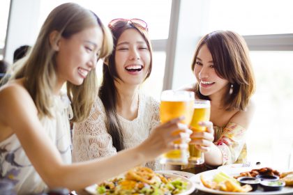 happy Group of girl friends toasting and eating in the  restaurant